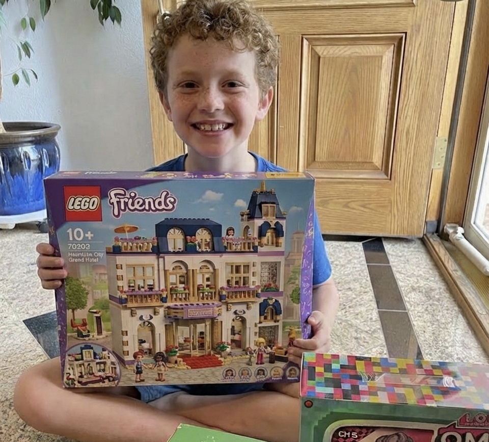 A young Detailing for MCAS supporter with a donated LEGO set for a patient care package
