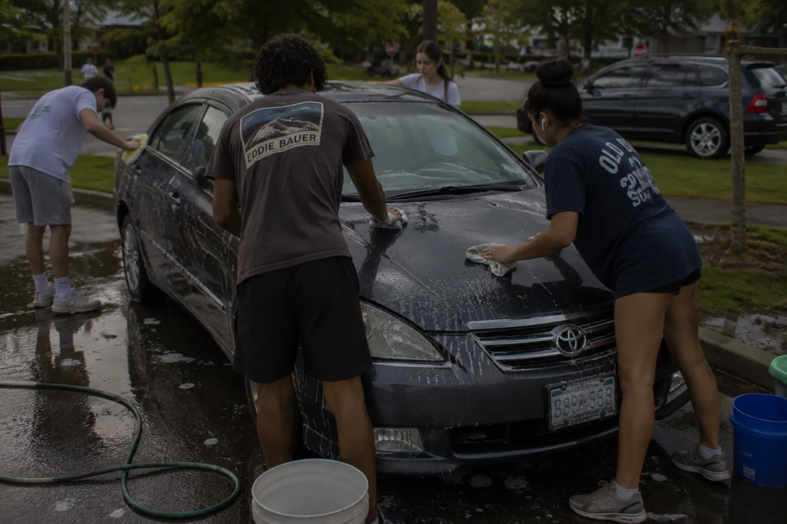 Young Detailers volunteers washing a car at a neighborhood fundraiser